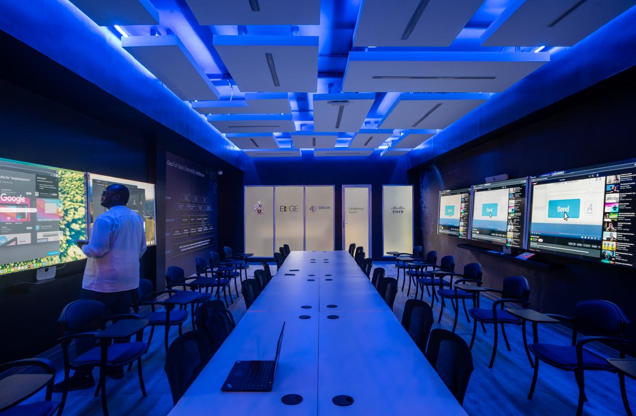 Blue-lit meeting room with presentation screens